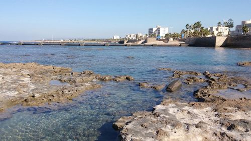 Cityscape by sea against sky