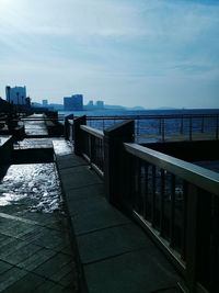 View of cityscape by sea against sky