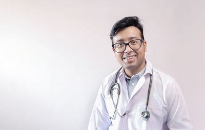 Portrait of smiling young man against white background