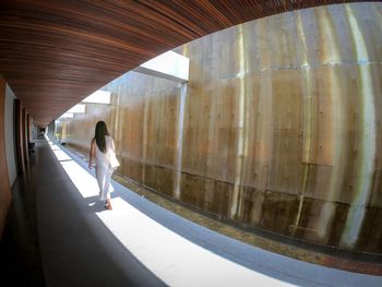 Rear view of woman walking in corridor