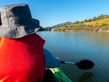 Rear view of man in lake against sky