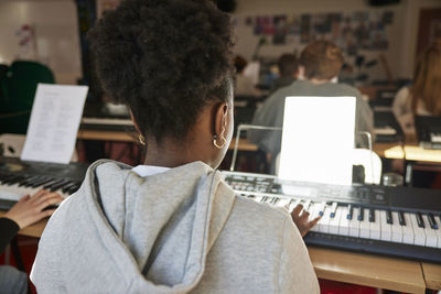 Teenagers attending keyboard lesson