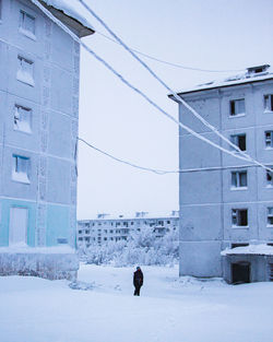 Rear view of man walking on snow