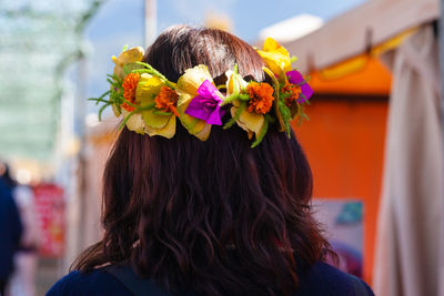 Rear view of woman with pink flower