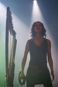 Woman with arms raised standing at music concert