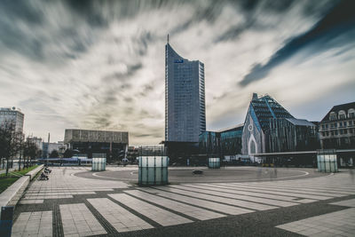 View of modern buildings against cloudy sky