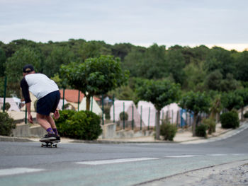 Rear view of man skateboarding at park