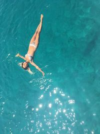 High angle view of woman swimming in pool on sunny day