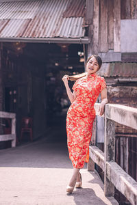 Portrait of woman against red building