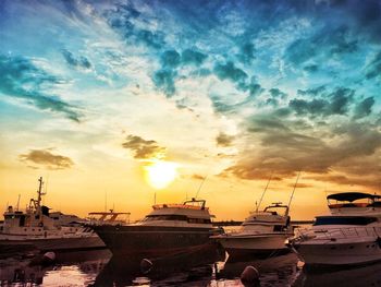 Boats in sea at sunset