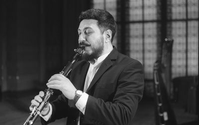 Man playing clarinet while standing at studio