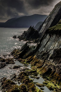 Scenic view of sea and mountains against sky