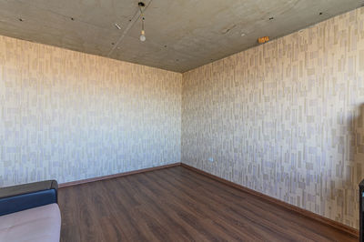 Empty wooden floor against wall