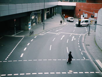 Rear view of woman walking on road in city