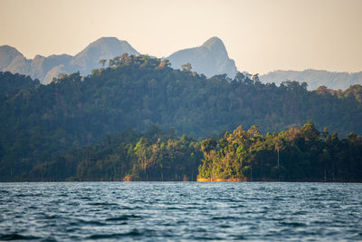 Scenic view of sea and mountains against clear sky