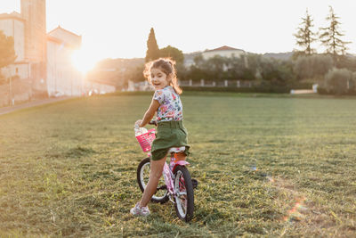 Side view of woman riding bicycle on field