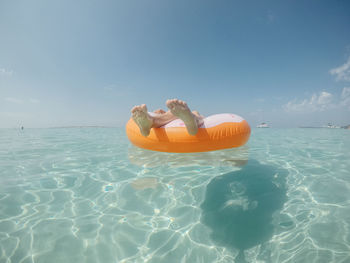 Person in sea by swimming pool against sky