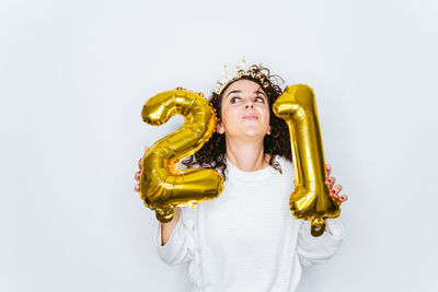 Smiling woman holding balloons against white backgrounds