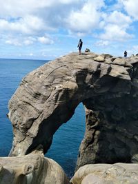 Rock formations on sea shore against sky