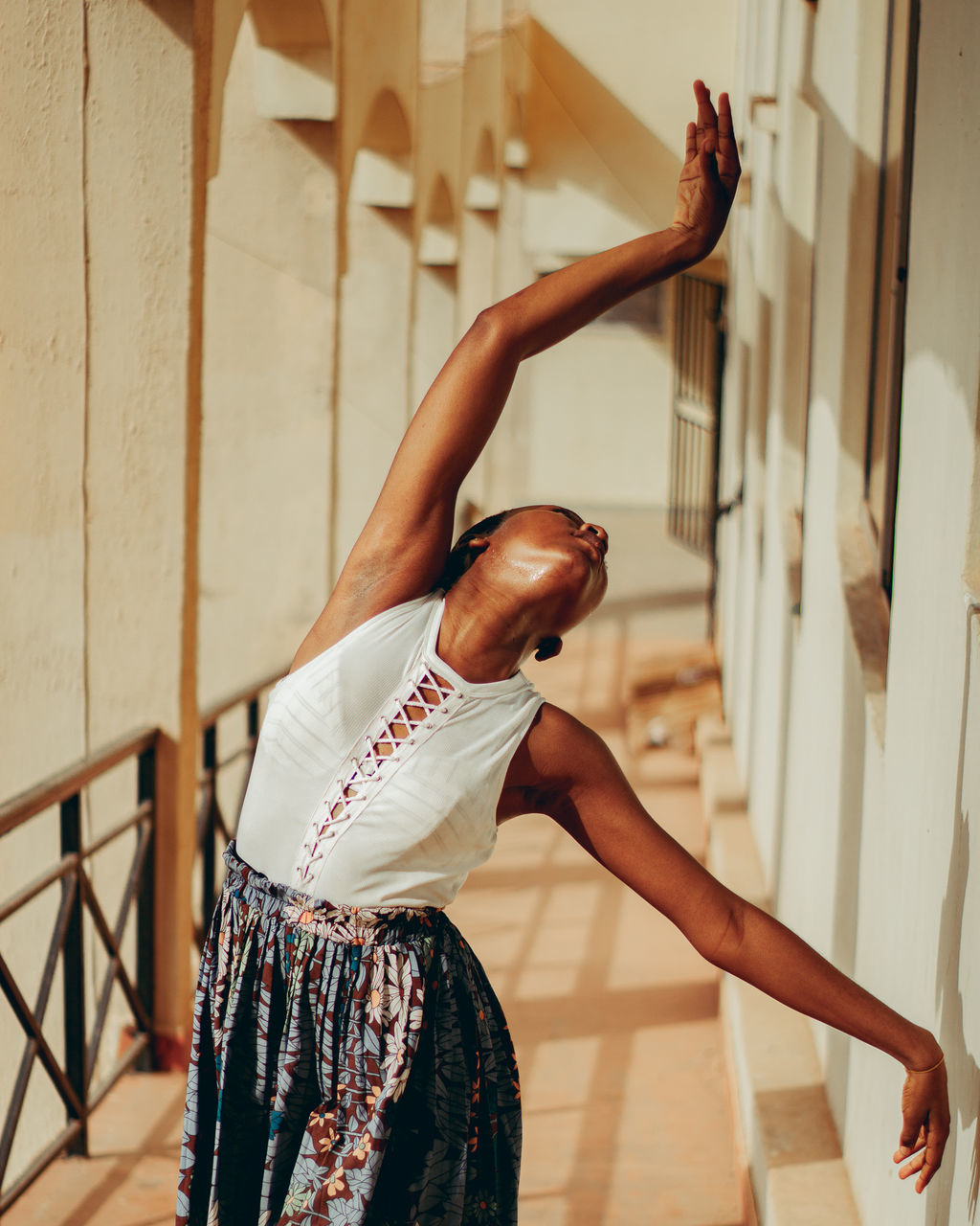 MIDSECTION OF WOMAN WITH ARMS RAISED STANDING