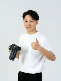 Portrait of young man standing against white background