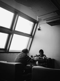 People playing piano seen through window