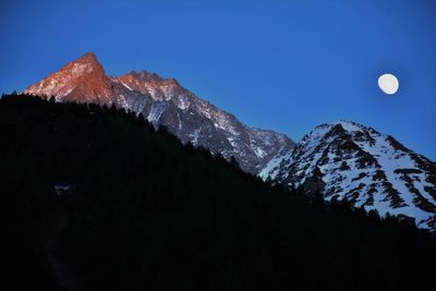 Scenic view of snowcapped mountains against sky at night