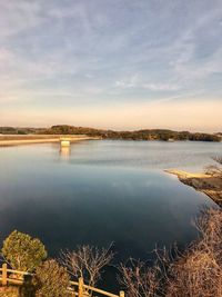 Scenic view of lake against sky at sunset