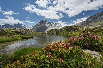 Scenic view of mountains and lake against cloudy sky