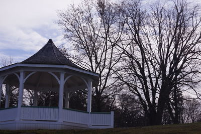 Low angle view of trees and building against sky