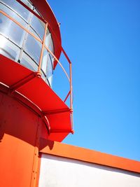 Low angle view of red umbrella against clear blue sky