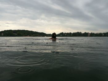 Rear view of woman in lake during rainy season