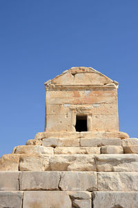 Low angle view of old ruin building against blue sky