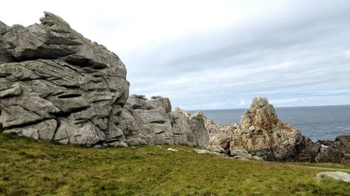 Scenic view of rocks in sea against sky