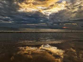 Scenic view of beach against dramatic sky