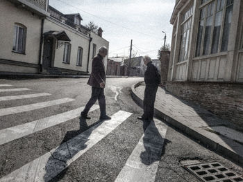People walking on street amidst buildings in city