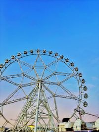 Low angle view of ferris wheel against clear blue sky