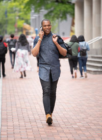 Full length portrait of man standing on footpath