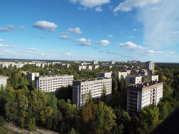 Buildings against cloudy sky in city on sunny day