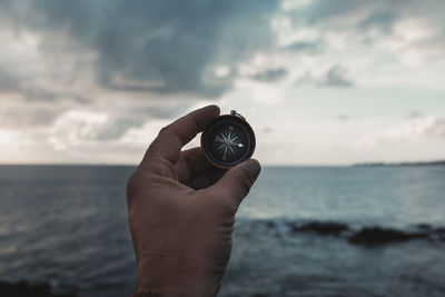 Cropped hand holding navigational compass