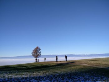 People by cloudscape on mountain