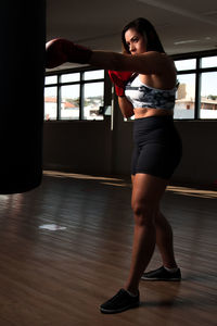 Full length of woman standing on wooden floor