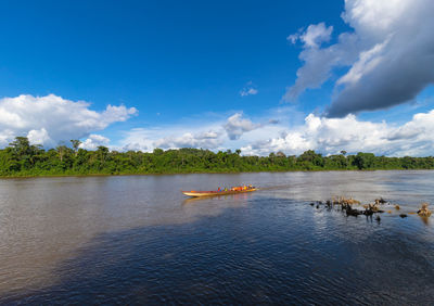 Tourists in traditional surinamese boat with life jackets