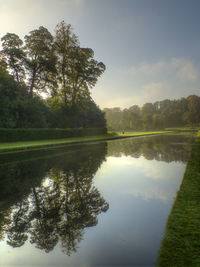 Reflection of trees in water against sky