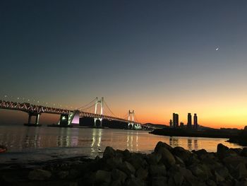 Bridge over calm sea against clear sky