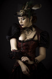 Woman in costume against black background