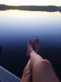 Low section of woman relaxing over sea against sky