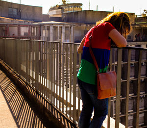 Rear view of woman standing by railing