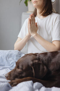 Midsection of woman with dog at home