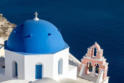 Building by sea against blue sky